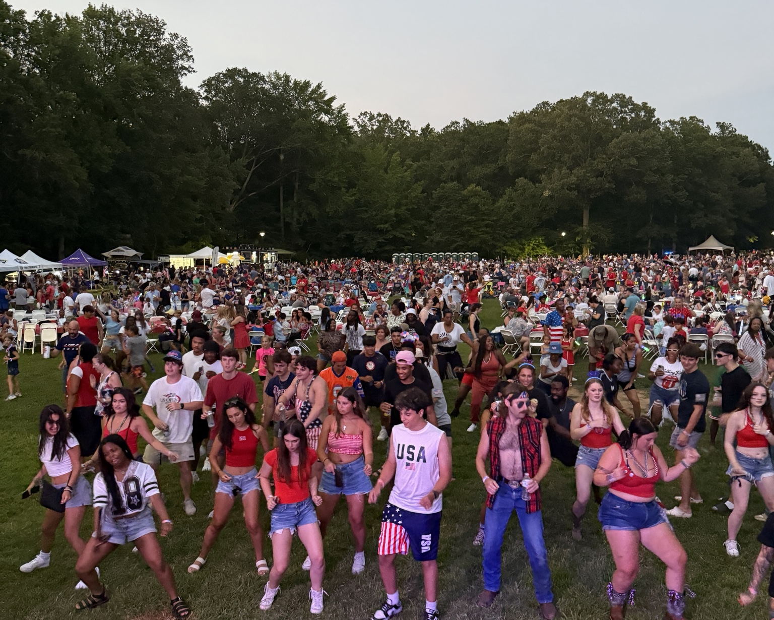 Large outdoor crowd dancing at an event